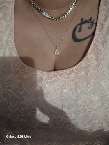 Customer wearing the delicate Divino Niño pendant and box chain on their chest.
