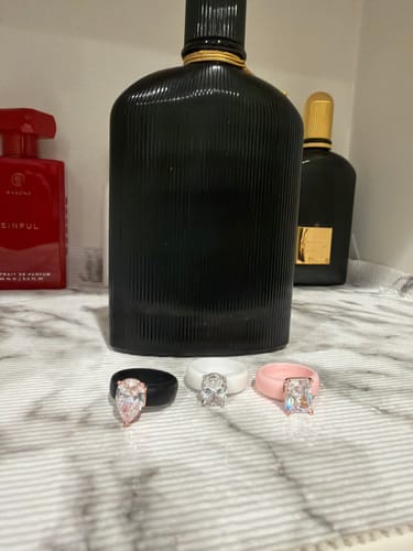 Customer displays three Silicone Rings, including the black pear-cut ring, on a counter.