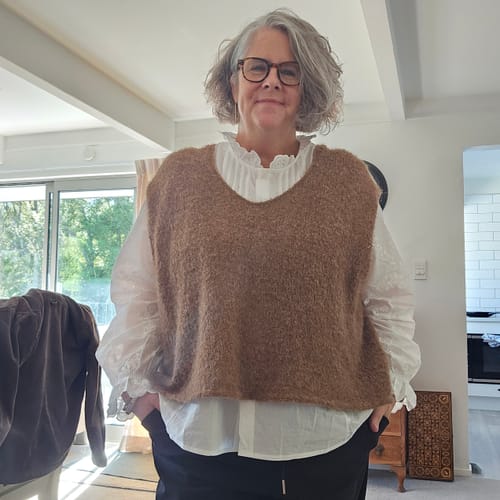 Customer wearing the white Artsy Cotton Shirt layered under a brown vest, showing its stand collar and roomy fit.