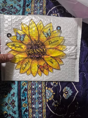 Customer's personalized sunflower suncatcher in its packaging, customized for 'Granny' with names written on the petals.