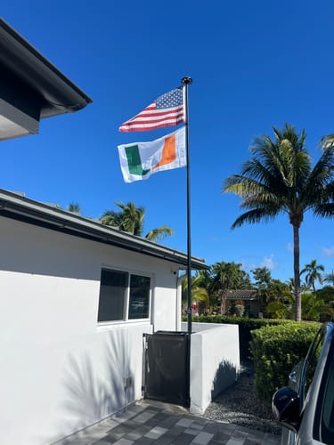 Customer's Ultra Heavy Duty American Flag flying on a flagpole above an Irish flag outside a home.