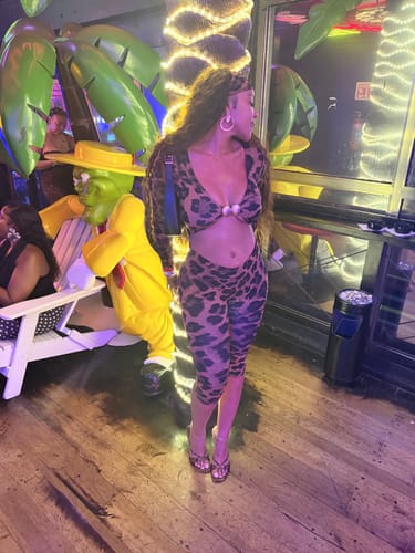 Customer's side view showing the fit of the bold Naked Print Cutout Capri Jumpsuit.