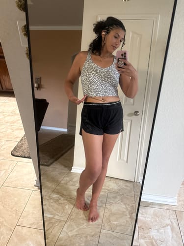Reviewer in a mirror selfie, showing the iridescent Royalty Lux Tie On Waist Beads worn with a crop top.
