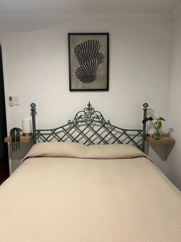 Customer's Sea Shells 01 Art Print in a black frame, hung on a white wall above an ornate, dark headboard.