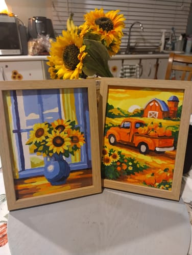 Customer's two framed mini paintings from the landscape set, one of sunflowers and one of a farm truck.