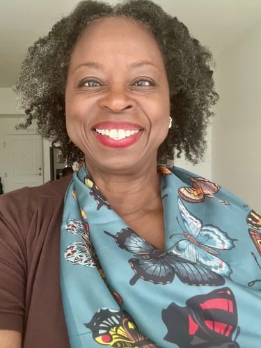Reviewer wearing the teal Wing Silky Scarf with a butterfly pattern around their neck.