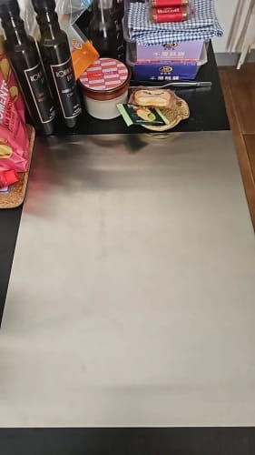 Customer photo review of Cette planche à découper en acier inoxydable est facile à nettoyer, double face et polyvalente, idéale pour manipuler les légumes de cuisine.