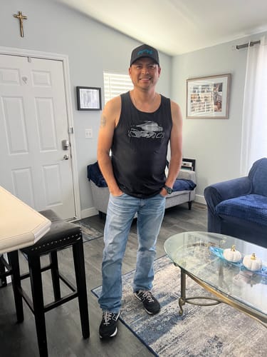 Customer standing indoors wearing the black 80Eighty Limited Edition DCG89 Tank with jeans and a cap.