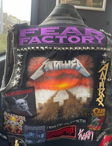 Customer's purple embroidered Fear Factory patch sewn onto the back of a studded denim vest.