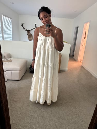 Customer wearing the flowy, ivory Noelle Strappy Tiered Satin Maxi Dress in a full-length mirror selfie.