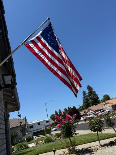 Customer's 1776 to 2026 Betsy Ross Flag flying from a flagpole outside a home on a sunny day.