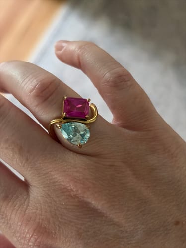 Customer wearing the gold Navae Birthstone Ring, featuring a rectangular pink stone and a pear-shaped light blue stone.