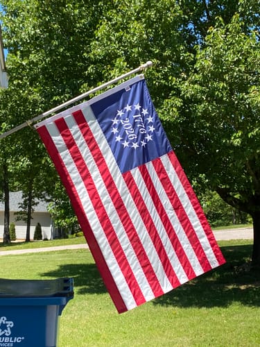 Customer's commemorative 1776 to 2026 Betsy Ross flag flying on a pole in a yard.