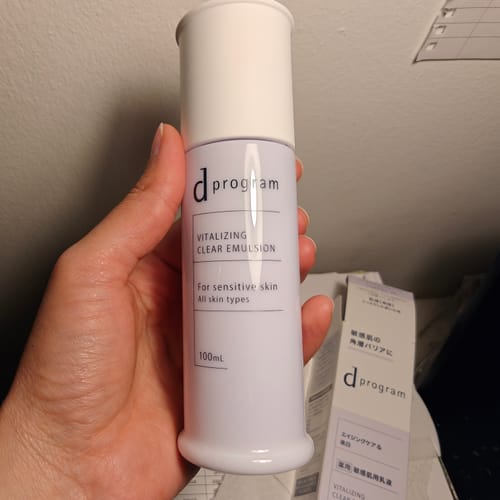 Customer holding the white bottle of d program Vitalizing Clear Emulsion.