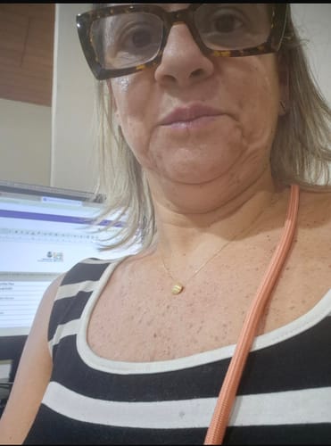 Avaliadora usando a Alça Universal Pêssego de forma transversal sobre uma blusa listrada.