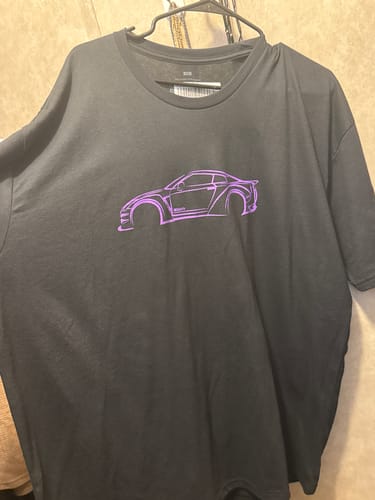 Customer's black 80Eighty® DCG88 Shirt with a purple car graphic, seen on a hanger.