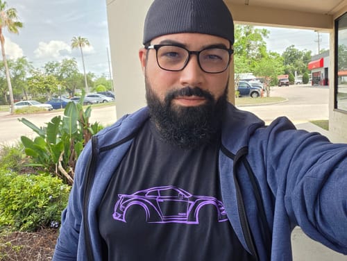 Customer wearing the black 80Eighty® DCG88 Shirt with a purple car graphic, under an open blue hoodie.