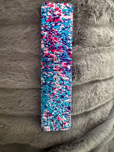 Customer's colorful splatter Weekly Case shown closed on a fluffy gray surface.