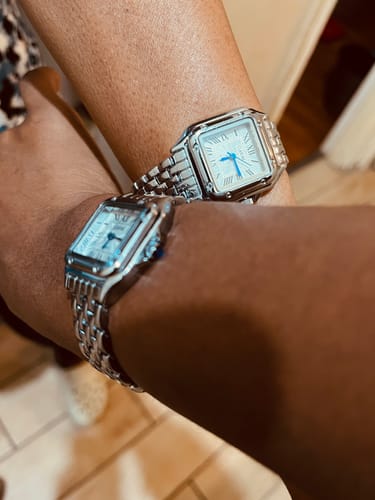 Customer's close-up of two matching silver GREALY DE MAINS watches on wrists.