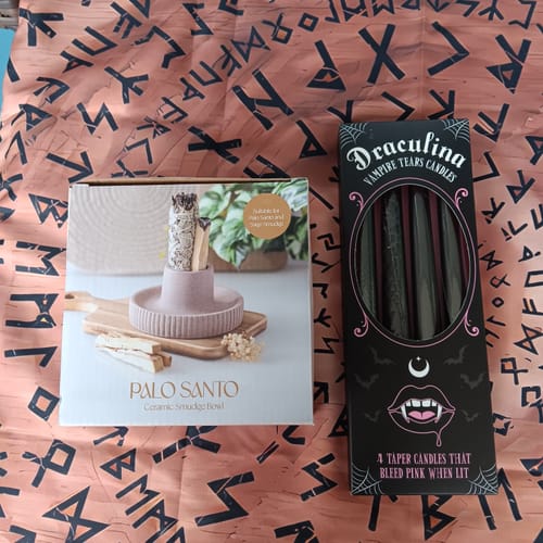Rezensent zeigt die Produktverpackungen einer Räucherschale und schwarzer Kerzen nebeneinander.