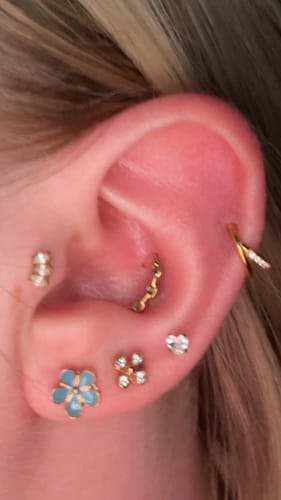 Close-up of a reviewer's ear styled with the gold Everyday Ear Party stud and hoop set.