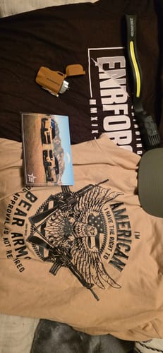 Customer's contents from the ENR#80 Exclusive Mystery Box laid out, featuring two graphic tees and various accessories.