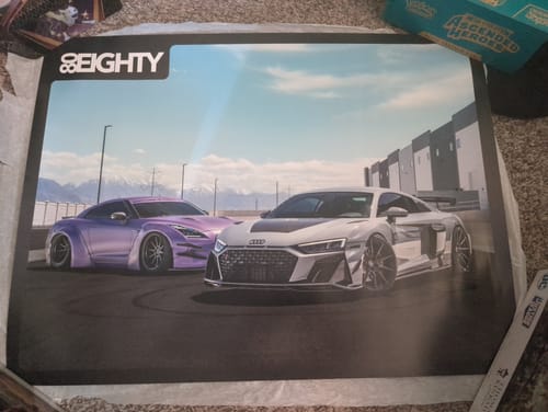 Customer's unframed 80Eighty DCG 88/89 Poster, showing a purple and a white sports car, laid out on a carpet.