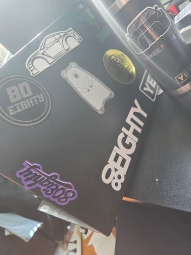 Customer's laptop and tumbler decorated with various stickers from the 80Eighty® DCG88 Sticker Pack.