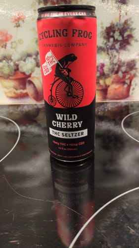 Customer's can of Wild Cherry THC Seltzer sitting on a black reflective stovetop.