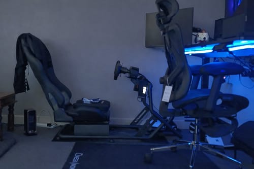 Reviewer's ON-22 ergonomic chair with the retractable footrest, seen in a gaming room next to a racing rig.