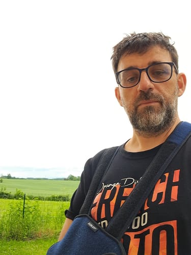 Client portant un T-shirt noir de la COLLECTION ORANGE DISTRICT en extérieur.