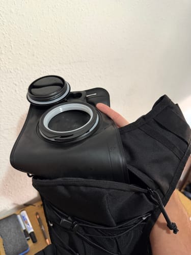 Recensore che inserisce la sacca ad acqua HydroRun nera all'interno di uno zaino da corsa.