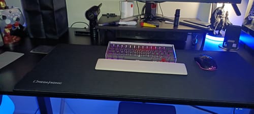 Reviewer's large black Omeganomic Mouse Mat covering a desk, with a keyboard and mouse on top.