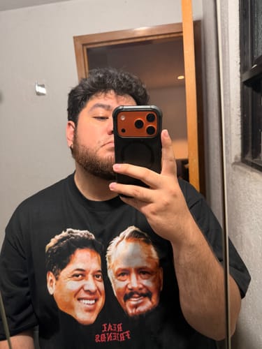 Cliente mostrando en una selfie la playera negra 'Real Friends (Paco & Mario)'.