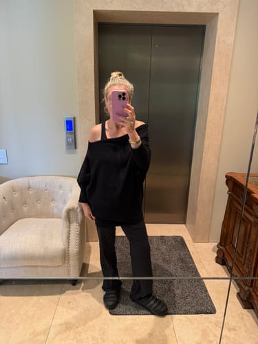 Reviewer demonstrates wearing the black Asymmetric Draped sweater upside down for a comfortable, off-the-shoulder fit.