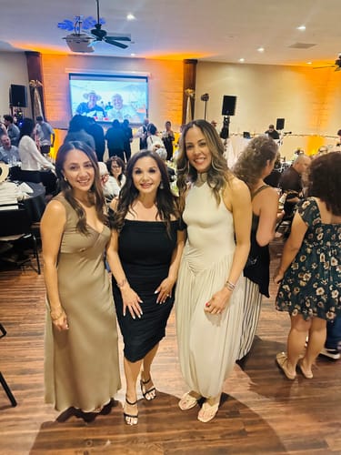Reviewer wearing the elegant, cream Naked Sleeveless Draped Midi Dress while posing with two people at an event.