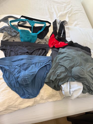 Reviewer showing the varied underwear styles from their Mega Value Mystery Pack laid out on a bed.