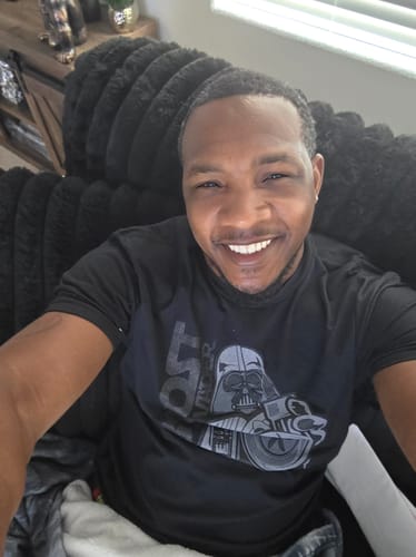 Reviewer smiling for a selfie in the black 80Eighty® BoostForce Shirt.