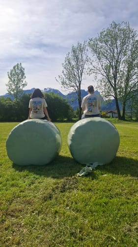 Rezensenten sitzen draußen und zeigen die Rückseite ihrer personalisierten One Love T-Shirts.