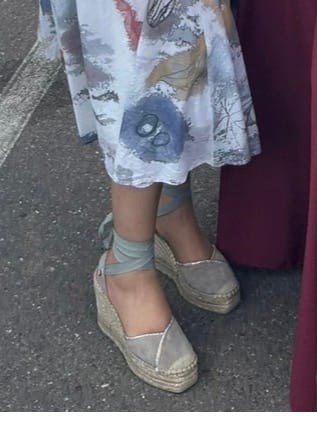 Una clienta llevando las Alpargata Leticia Gris de cuña con cintas atadas al tobillo.