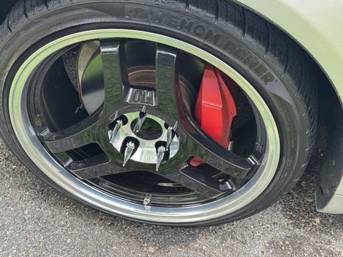 Customer's close-up of silver Spline Spike Lug Nuts installed on a black custom wheel.