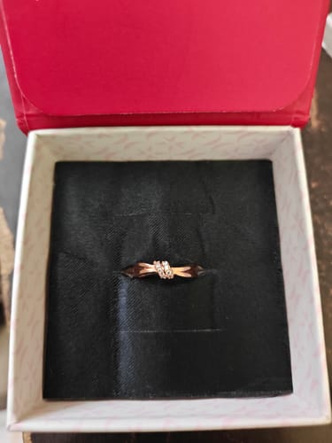 Customer's Rose Gold Promise Knot Ring with a zircon knot, seen inside its presentation box.