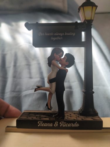 Customer's personalized wooden plaque with a couple kissing under a lamppost. The names 'Ileana & Ricardo' are on the base.