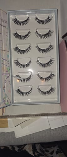 Ein Kunde zeigt die geöffnete Box des AYLASHES Bundle Builders mit sechs Paar hochwertigen Wimpernextensions.