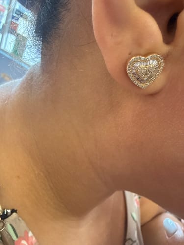 Close-up of a customer wearing the sparkling 14k Heart Baguette Diamond Earring.