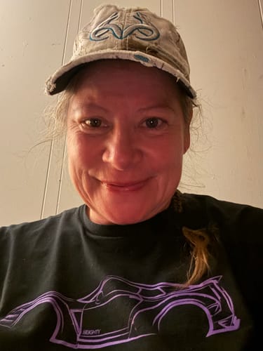 Reviewer smiling in a close-up photo, wearing the black 80Eighty DCG88 Shirt with a purple graphic.