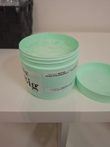 Photo d'un client montrant le pot ouvert du Masque Gamme Résistance, avec sa texture crémeuse visible sur une table blanche.