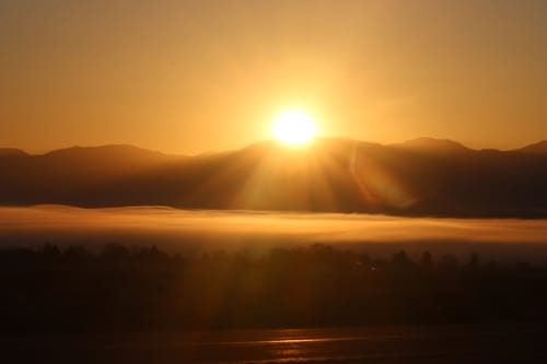 Reviewer's photo of a golden sunrise over a foggy mountain valley.