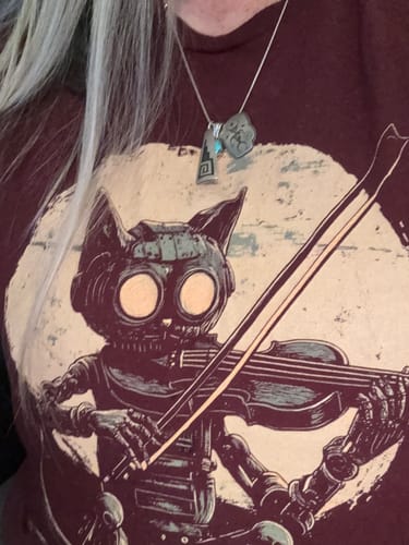 Close-up of a reviewer wearing the dark Artificial Art t-shirt, featuring a cat-like robot playing a violin.