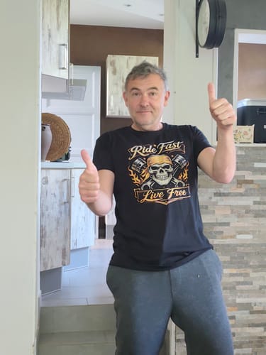 Un client portant le t-shirt noir Pirate Ride Fast Live Free, souriant et levant les deux pouces.